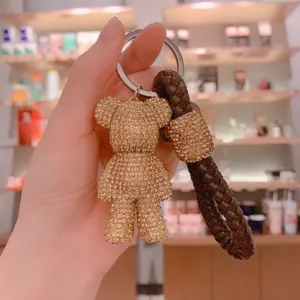 Primo piano dettagliato del portachiavi con orsetto in strass scintillanti e cinturino in pelle.