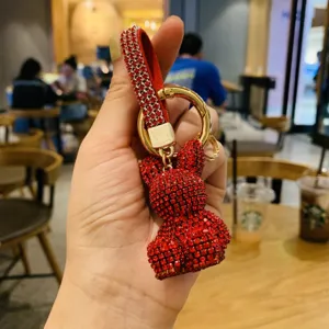 Red rhinestone rabbit keychain with gold hardware and leather strap, sparkling charm.