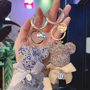 Rhinestone big head bear keychain with bow and letter charm, sparkling metal bag pendant.