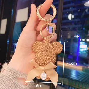Rhinestone big head bear keychain with bow and letter L charm, cute metal bag pendant accessory.