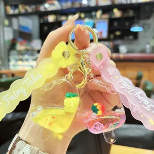 Cute acrylic liquid quicksand keychain with pineapple and strawberry charms for bag or keys charm.