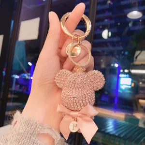 Detailed view of the sparkling rhinestone bear keychain with pink bow and letter pendant.