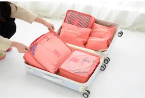 Detailed view of pink travel organizer packing cubes set neatly arranged inside suitcase.