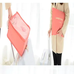 Pink travel laundry pouch detail view, portable clothes organizer bag for suitcase travel packing.