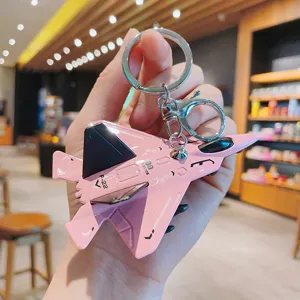 Close-up of pink alloy fighter jet keychain showing metal texture and engraved F-22 detail.