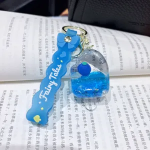 Acrylic liquid flowing keychain with cute blue charm and glitter design detail shot.