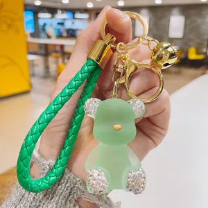 Green jelly bear keychain with sparkling rhinestones, braided strap and gold metal keyring.