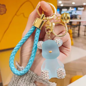 Blue jelly bear keychain with sparkling rhinestones, gold hardware, and chic braided strap.