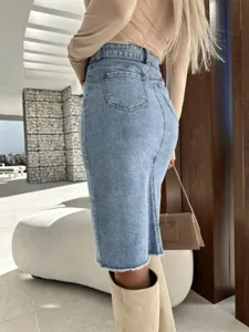 Gonna midi in denim blu con dettaglio a vita alta, vestibilità slim e orlo sfrangiato.