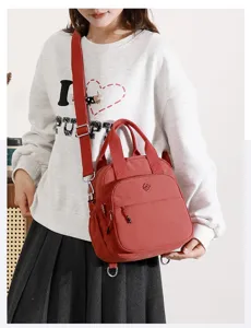Bolso bandolera informal de nailon rojo con correa ajustable y práctico bolsillo delantero.