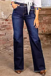Primo piano dettagliato dei jeans da donna blu scuro con vita e orlo sfrangiati alla moda.