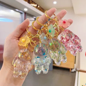 Dettaglio ravvicinato del portachiavi a coniglietto con glitter trasparenti e ciondoli floreali.