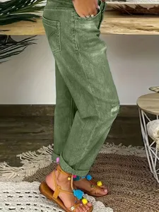 Vue détaillée de jean extensible vert pour femmes, ourlets retournés et style streetwear chic.