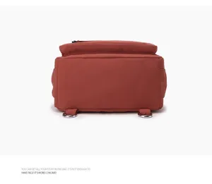 Vista detallada de la parte inferior y trasera de la mochila de nailon marrón rojizo con anillos en D.