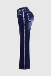 Dettaglio di jeans da donna blu scuro con bordi sfrangiati alla moda e vita alta.