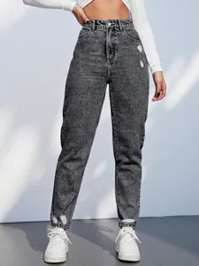 Gedetailleerd overzicht van high waist acid wash mom jeans met destroyed details.