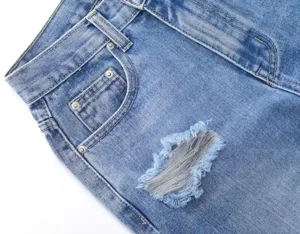 Detailed close-up of women's ripped denim jeans, casual light blue straight leg pants.
