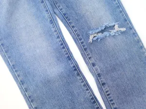 Detailed view of light blue straight leg women jeans featuring knee distressing raw hem design.