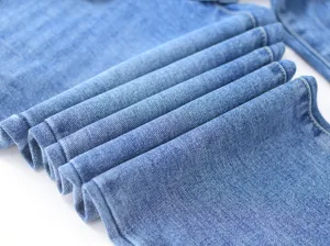 Close up detail shot of stylish blue denim jeans fabric texture and fine stitching work.