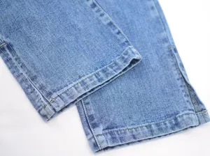 Close-up detail of women blue denim jeans cuff with side slit and yellow stitching.
