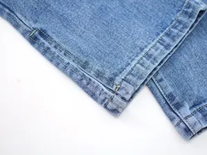 Detailed view of women denim pants split hem craftsmanship and stitching quality.