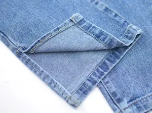 Close-up view of women's denim jeans hem with stylish side slit and contrast yellow stitching detail.