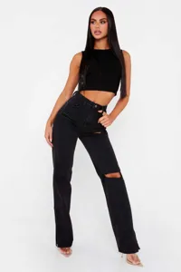 Close-up detail of black straight leg denim pants featuring stylish knee rips and chic slit hems.
