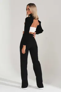Detailed back view of women's black straight leg denim jeans paired with a stylish black knit shrug.