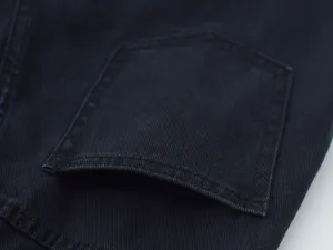 Close-up detail of dark denim jeans pocket, featuring durable fabric and neat stitching.