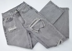 Grey distressed straight leg denim jeans detail showing ripped knees and classic washed texture.