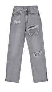 Grey distressed denim jeans detail showing knee rips and stylish bottom hem side slits.