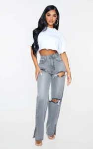 Detailed view of women's high-waisted distressed grey straight leg jeans with slit hem design.