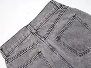 Close-up detail of women's gray denim jeans featuring back pockets and waistband.