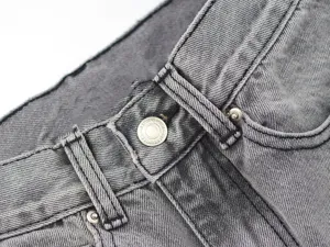 Grey denim jeans waistband detail, metal button and sturdy belt loops, vintage style.