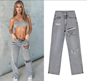 Grey distressed straight leg jeans detail shot showing ripped knees and split hem design.