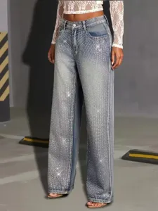 Detail view of trendy rhinestone embellished denim jeans featuring a high waist and wide leg fit.