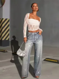 Stylish rhinestone wide-leg jeans paired with a chic white lace top and silver shoulder bag.