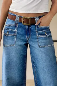 Detailed shot of casual blue wide-leg denim jeans with multi-pocket design and contrast stitching.