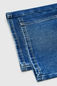 Close-up detail of women's blue denim jeans featuring durable stitching and classic fabric texture.