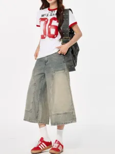 Detail shot of vintage washed denim culottes paired with casual outfit, stylish wide leg fit.