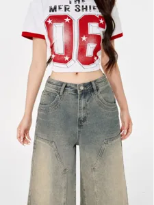 Retro women's loose wide leg washed denim jeans paired with graphic print tee detail shot.