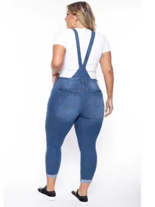 Plus size blue denim overalls for women with stretch washed finish and stylish straps.