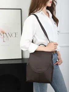Dark brown genuine leather backpack, casual soft cowhide school bag with stylish design details.