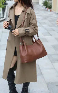 Detail shot of brown cowhide leather shoulder bag, casual everyday commuting tote style.