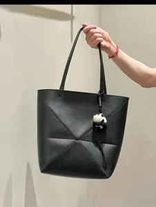 Detailansicht der schwarzen Leder-Tragetasche mit ihrem einzigartigen geometrischen Faltenmuster.