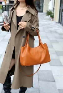 Brown leather shoulder bag detail shot, minimalist commuter tote bag with large capacity.