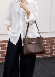 Brown leather shoulder bag for women, classic Kelly design with metal turn-lock closure.