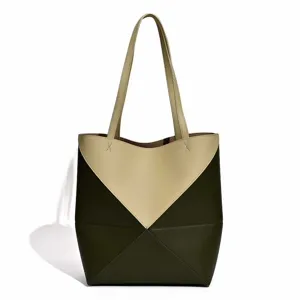 Detailansicht der stylischen, zweifarbigen geometrischen Ledertasche mit doppelten Henkeln.