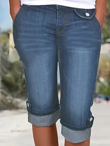 Gros plan sur les details du pantalon capri en denim pour femme avec revers et stretch.