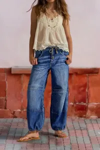 Close-up detail of women's casual loose wide-leg denim pants with drawstring and cuff.